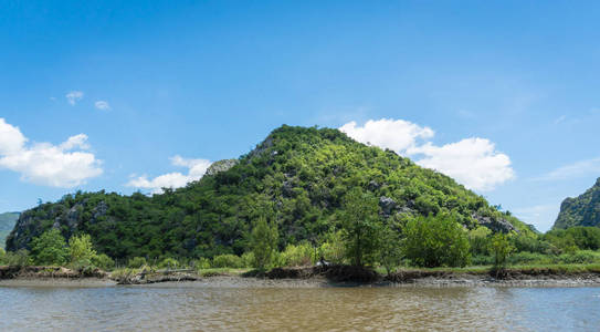 石头或岩石山或小山，有绿色的树，蓝天，水和云，在泰国的KhaoDang运河Khiri Khan泰国。 风景或风景夏季概念船游