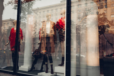 在市中心的一家商店的橱窗里，穿着秋天的服装的人称。 购物和销售概念。 黑色星期五