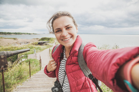 美丽的年轻女旅行者在芬兰的一个岛屿上自拍