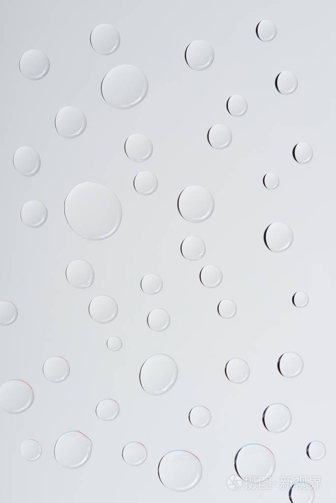 浅灰色背景下透明水滴近景