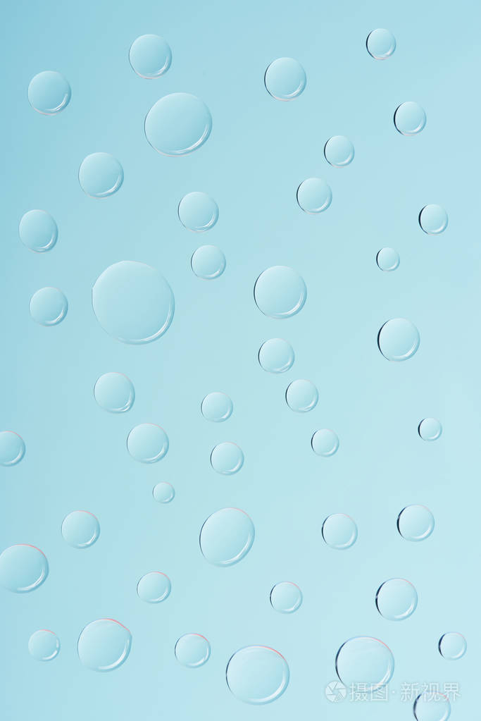 在浅蓝色背景上近距离观看透明水滴