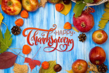 感谢信。 秋天明亮的背景。 蓝色木制背景上的花朵叶子和水果。 秋季假期和感恩节的背景。