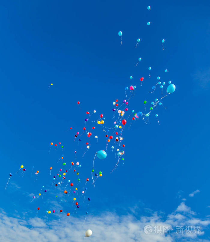 许多飞气球与氦在蓝天与云彩