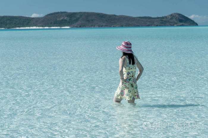 女人有五颜六色的帽子，美丽的海景。 旅行概念。