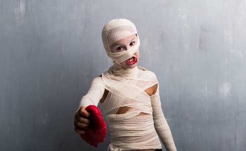 穿木乃伊服装的男孩带着心度过万圣节照片