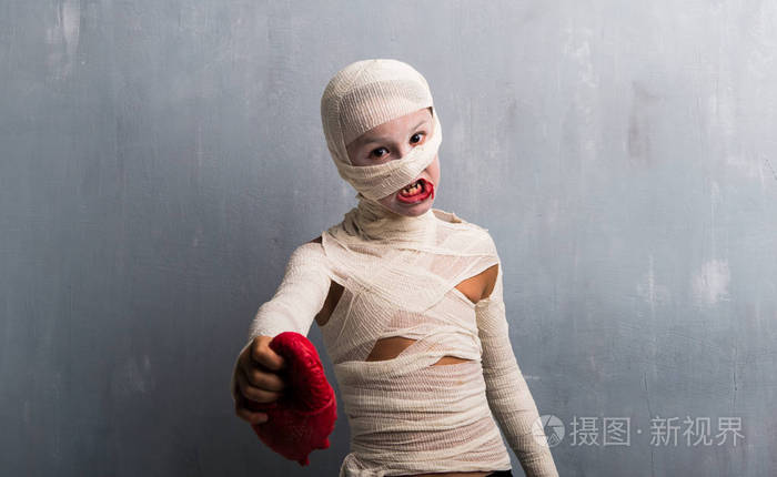 穿木乃伊服装的男孩带着心度过万圣节