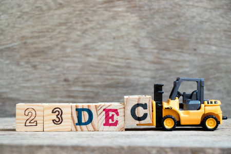 玩具叉车保持块c完成字23dec在木材背景概念日历日期23在12月月份