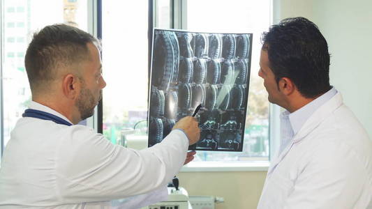 有经验的医生正在研究他们的病人的 x 光片