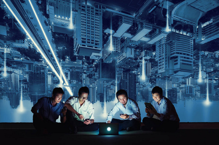 亚洲商务集团穿着休闲服，使用智能手机平板电脑和笔记本电脑进行工作或社交网络。 商业和技术概念