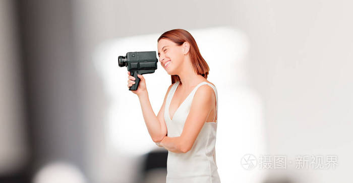 年轻漂亮的女人带着老式的摄像机