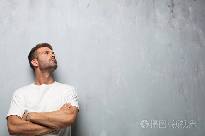 年轻的英俊男子微笑着,抬头,侧身向天空或地点,在那里,公关人员可以