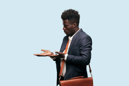 年轻的黑人商人微笑着,带着自豪,满意和快乐的表情,欢迎手势或展示和