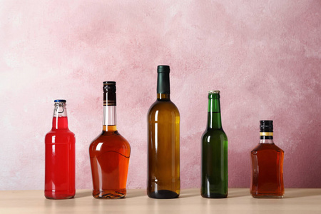 桌上装有不同酒精饮料的瓶子,颜色背景照片