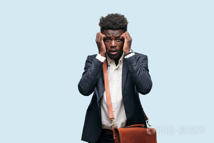 年轻的黑人商人用一种紧张的手势双手紧握着半张遮住的脸