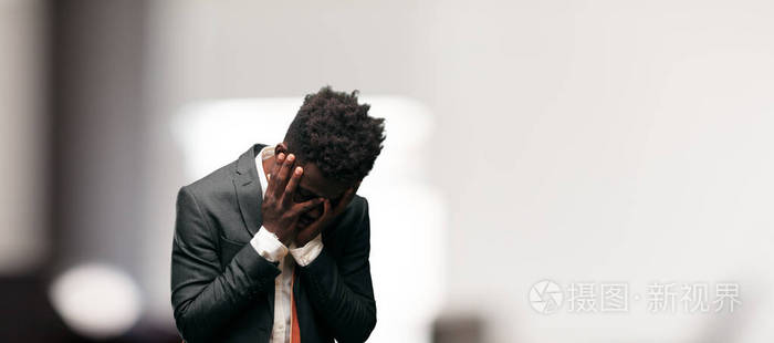 年轻的黑人商人带着失望和失败的悲伤表情看上去沮丧绝望痛苦不堪