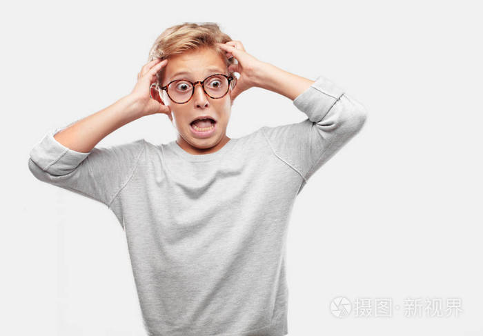年轻的金发帅哥带着一种疯狂的惊讶表情双手拉着头发抱着头