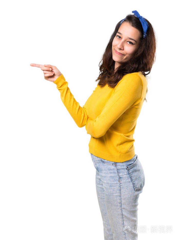 年轻女孩头上戴着黄色毛衣和蓝色手帕手指指向侧面在孤立的白色背景上