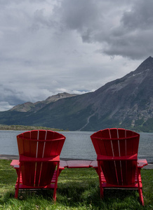红椅子从草地上俯瞰水潭图片