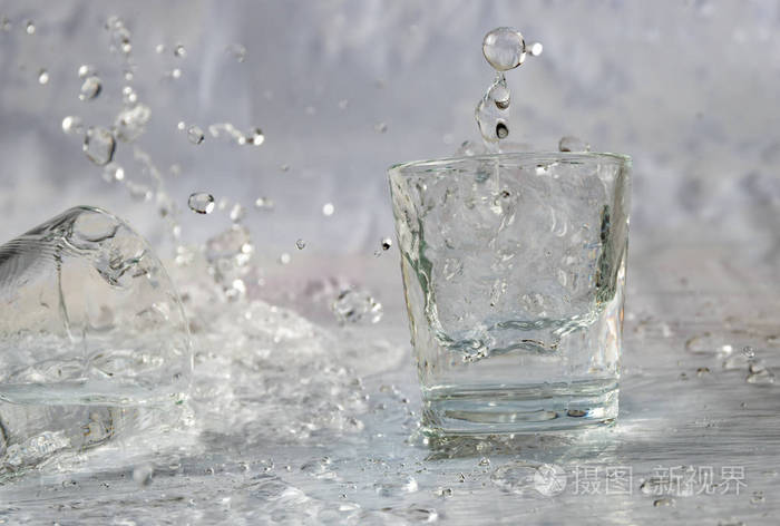 杯子里的水掉下来,溅起水花和水滴