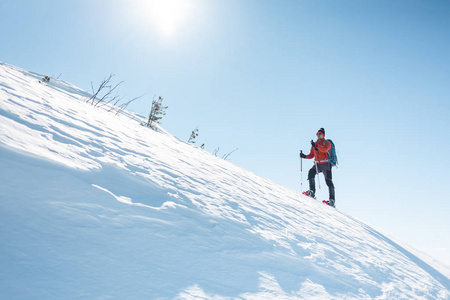 穿雪鞋的登山者背着一个背包。 冬天在山上旅行。 大自然中的极端假期。