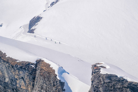 在瑞士一个美丽的晴天，滑雪者独自带着头盔在滑雪坡上滑向马特霍恩山。