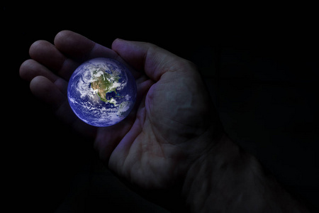 地球仪一只手握着。 这幅图像的元素由美国宇航局提供。