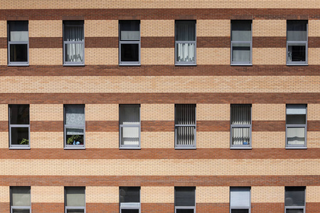 城市房屋的窗户.百叶窗和百叶窗.条纹红黄色的墙.办公楼.照片