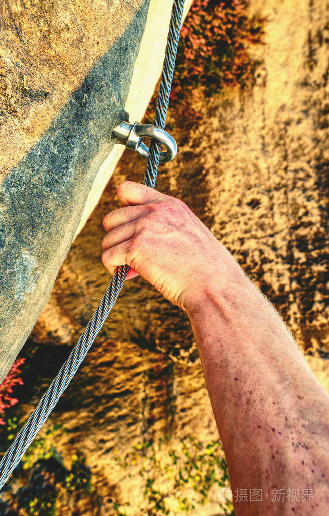 男性登山者手连接通过费拉塔设置到钢电缆. 向上爬
