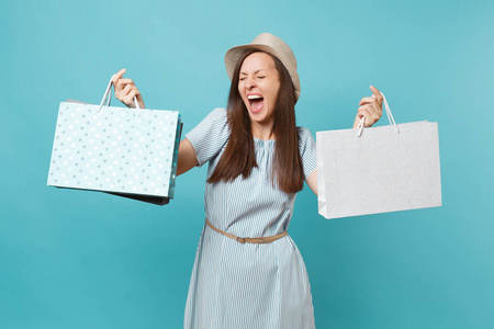 肖像兴奋，微笑，美丽的高加索女人，穿着夏装，草帽，拿着包裹袋，购物后，孤立在蓝色的粉彩背景上。 广告复制空间