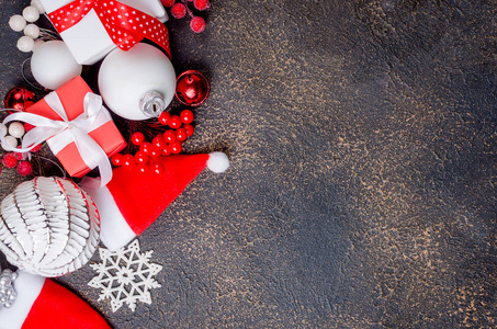 红白相间的礼品盒，带丝带和节日装饰球，玩具在黑暗背景下的圣诞贺卡复制空间