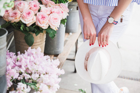 时尚女性在户外靠近鲜花的帽子摄影