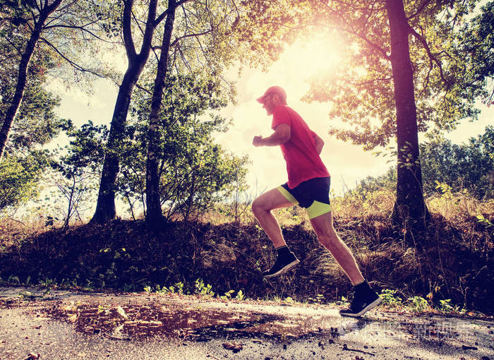 在阳光明媚的秋天早晨体育人物正在公园小巷里跑步保持良好状态健康的