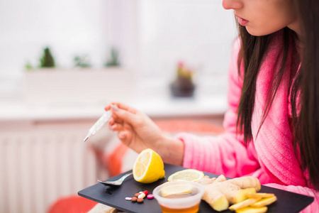 把生病的妇女放在桌子上，把食物和药品放在家里，把体温计拿在手里