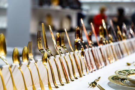 商店柜台上有铜铜和金叉刀和勺子。