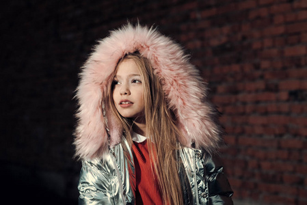时尚的孩子穿着时髦的大衣与毛皮罩。时尚潮流与风格理念