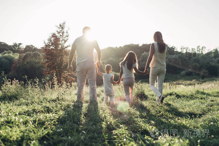 成人夫妇和他们的孩子在城外的公园野餐家庭周末概念四人享受夏天
