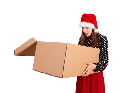 震惊和惊讶的漂亮年轻女人拿着打开的大纸箱礼盒。 孤立在白色背景上。 假日概念。