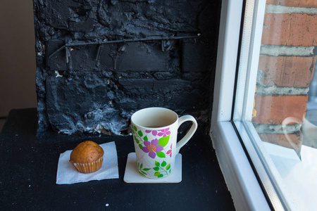 窗户附近有茶和蛋糕的杯子