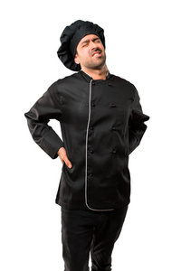 穿着黑色制服的厨师长不高兴，并因在孤立的白色背景上做出努力而背痛
