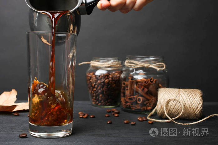 热咖啡倒在黑色背景上的玻璃里