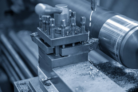 车床在浅蓝色场景下切割钢轴的操作.照片