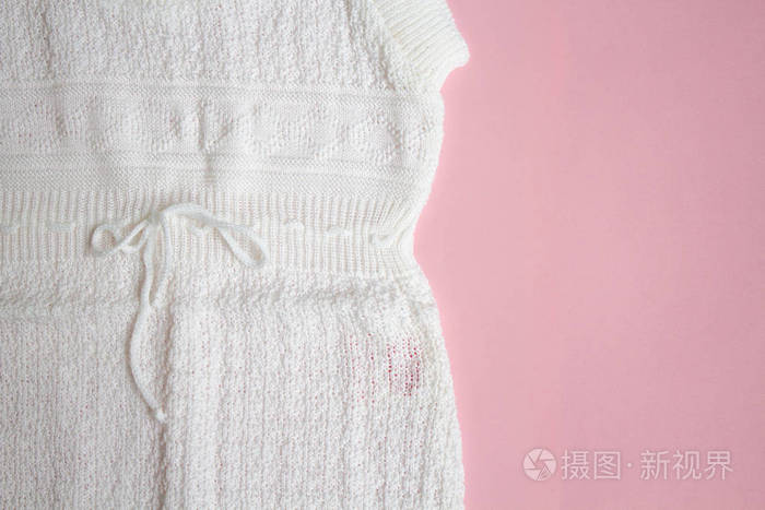 s knitted clothes on pink background.