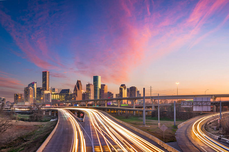 休斯顿，德克萨斯州，美国市中心的天际线在黄昏的高速公路上。