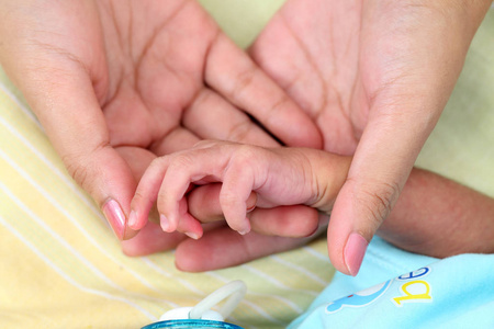 s hand grasping the finger of parent