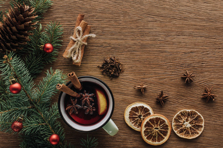 木制桌面圣诞概念上覆盖葡萄酒干橙和冷杉树枝的顶部视图