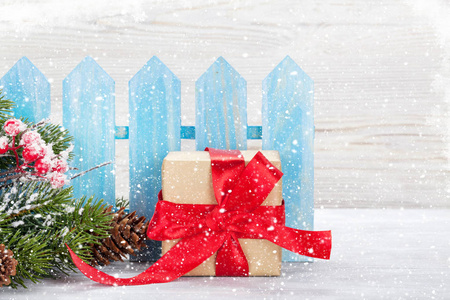 圣诞礼盒和圣诞杉树枝靠近蓝围栏