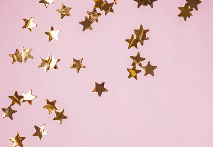 粉红色背景的金色闪亮装饰星星, 顶部视图