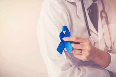 医生手拿浅蓝色丝带，前列腺癌意识