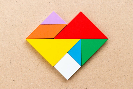 的彩色缠结拼图猫坐在白色背景上的形状的木质七巧板拼图木工特写手