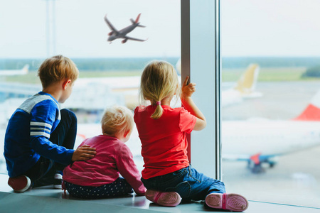 孩子们等待飞机在机场，家庭旅行